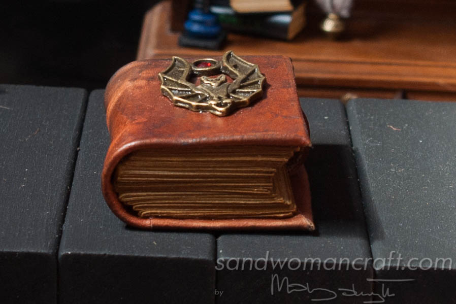 Miniature leather bound book with bat in 1:6 scale