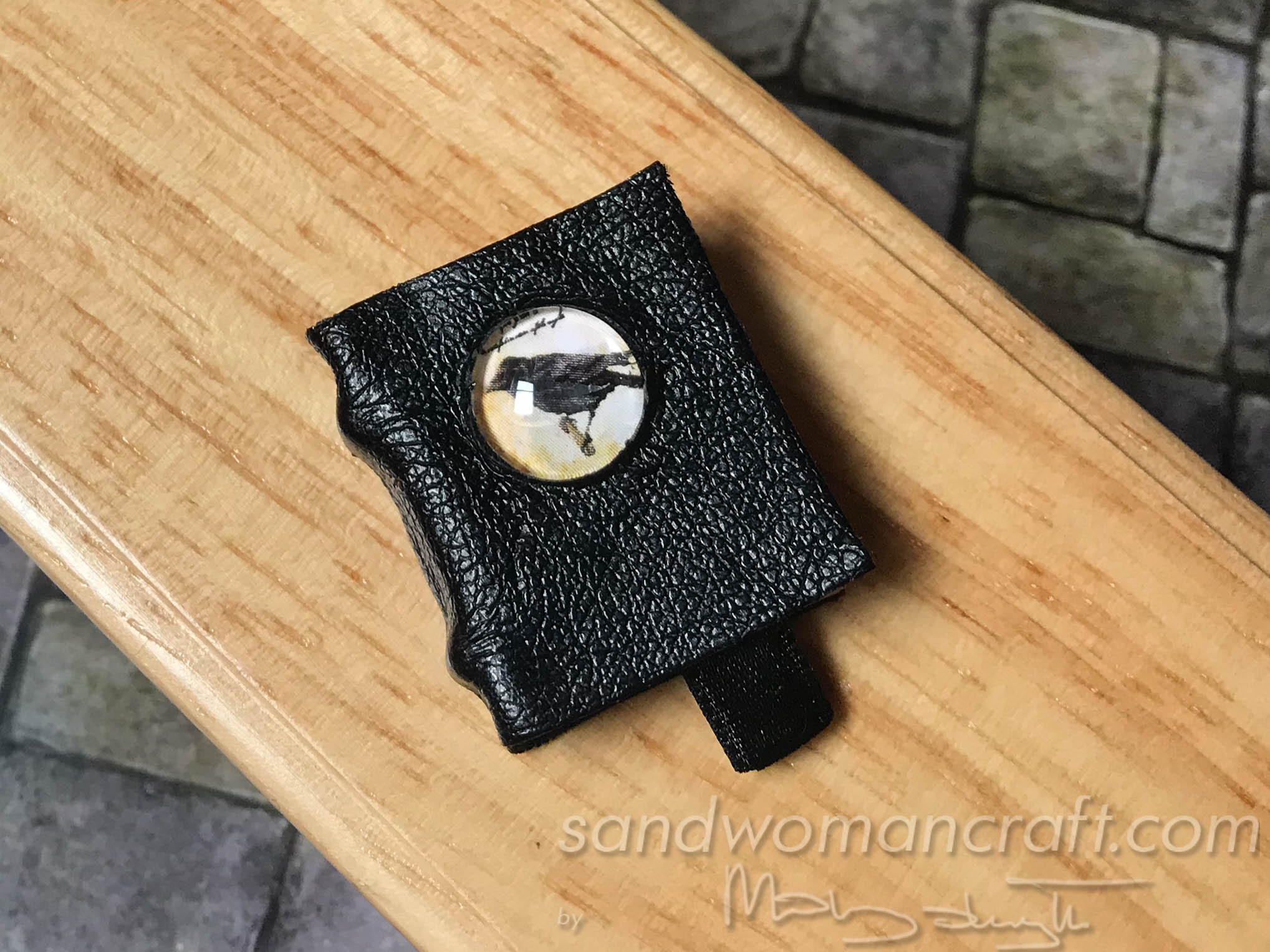Miniature leather book with crow
