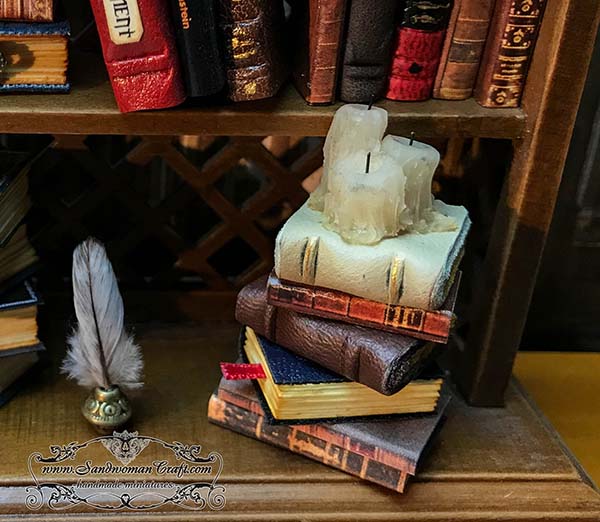 Miniature books stack with three candles