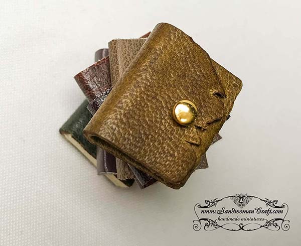 Miniature leather books with leather journal at the top
